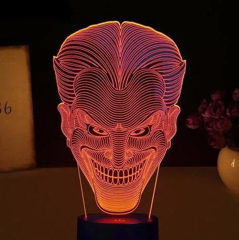 A 3D acrylic LED desk lamp showing multicolour gradient lighting, sitting on its square base with a USB cable.