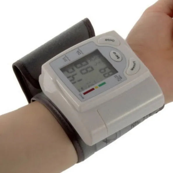 Grey portable wrist blood pressure monitor with digital display showing measurements