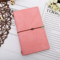 A6 diary with cowhide rope binding in grey, pink, or red colour options lying open