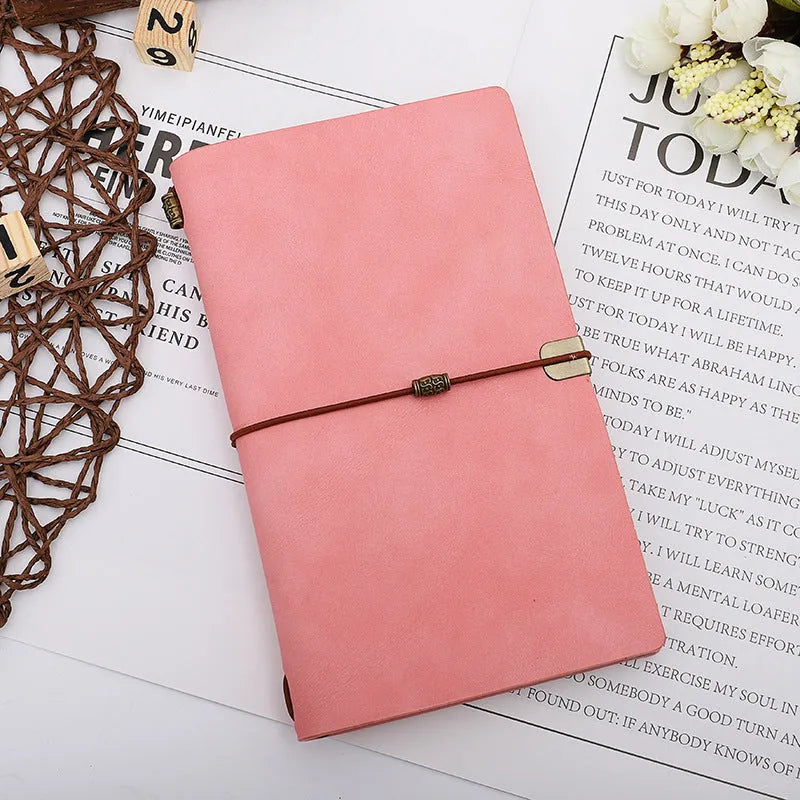 A6 diary with cowhide rope binding in grey, pink, or red colour options lying open