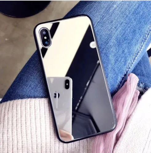 Black mirror back cover phone case for Apple iPhone X, 11, 12, 7, 8, and 6 models on a table.