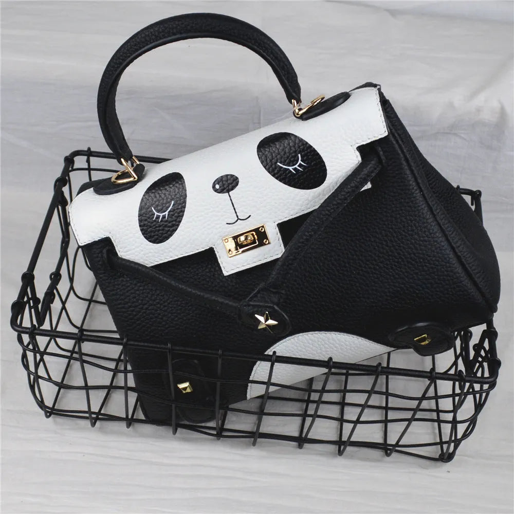 Black and white panda print on a structured horizontal square cowhide leather handbag with top handles.