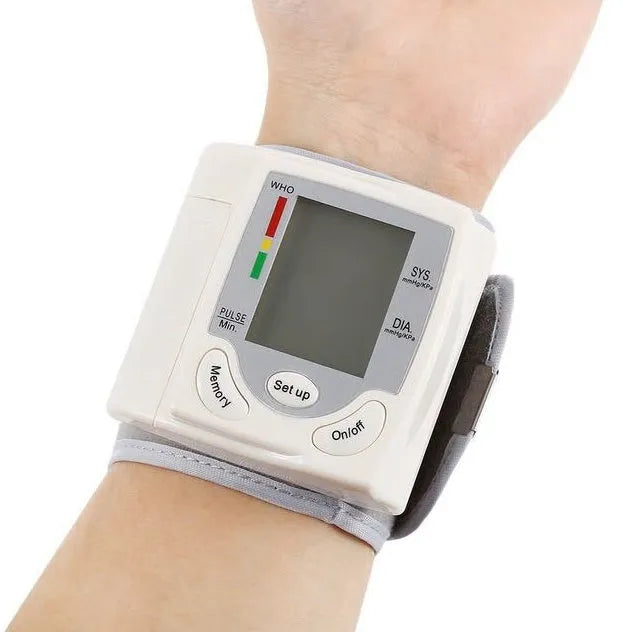 Grey portable wrist blood pressure monitor with digital display showing measurements