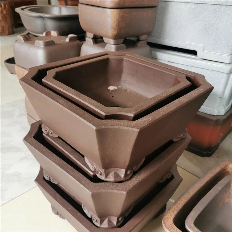 Set of two square stump purple sand flowerpots in brown finish on a flat surface