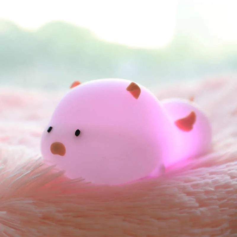 Blue or pink pig silicone night light with sleeping design, shown with dimensions and rechargeable battery.
