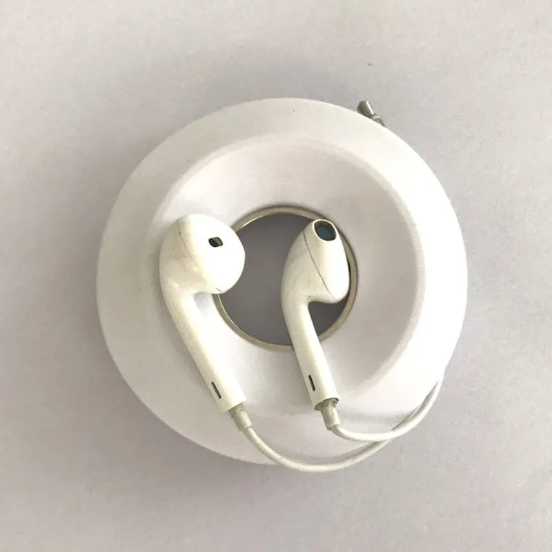 Silicone donut cord reel with suction cup and magnet for organising mobile phone and headphone cables