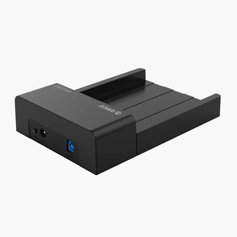 Black plastic 2.5 inch SATA hard drive enclosure with USB cable on a desk