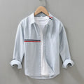 Hong Kong style loose fit cotton blend shirt in light blue, showing cardigan design on a hanger.