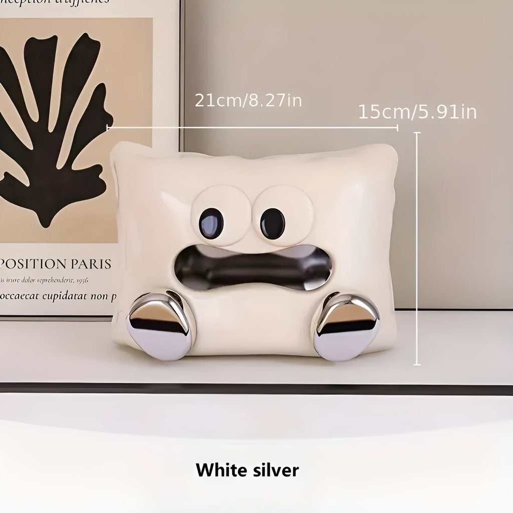 A white ceramic tissue box holder on a wooden coffee table.