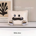 A white ceramic tissue box holder on a wooden coffee table.