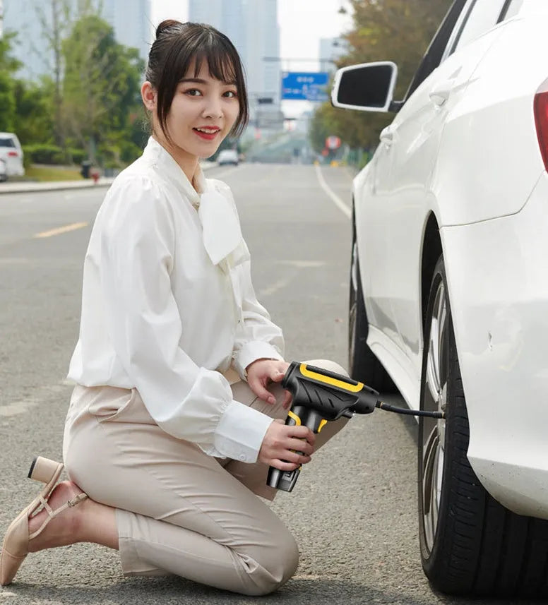 Wireless handheld air pump in black with LED light and pressure gauge, inflating a car tyre