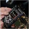 Perfume bottle design iPhone case with metal chain strap in black, shown on an iPhone.