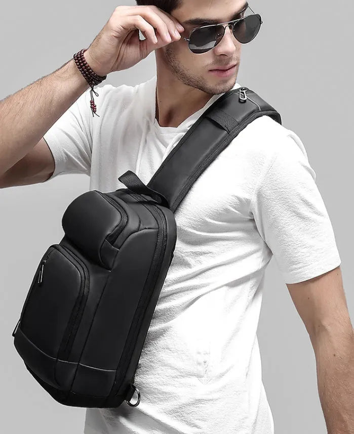 Black medium outdoor PVC shoulder bag with an air cushion strap and organiser pockets.