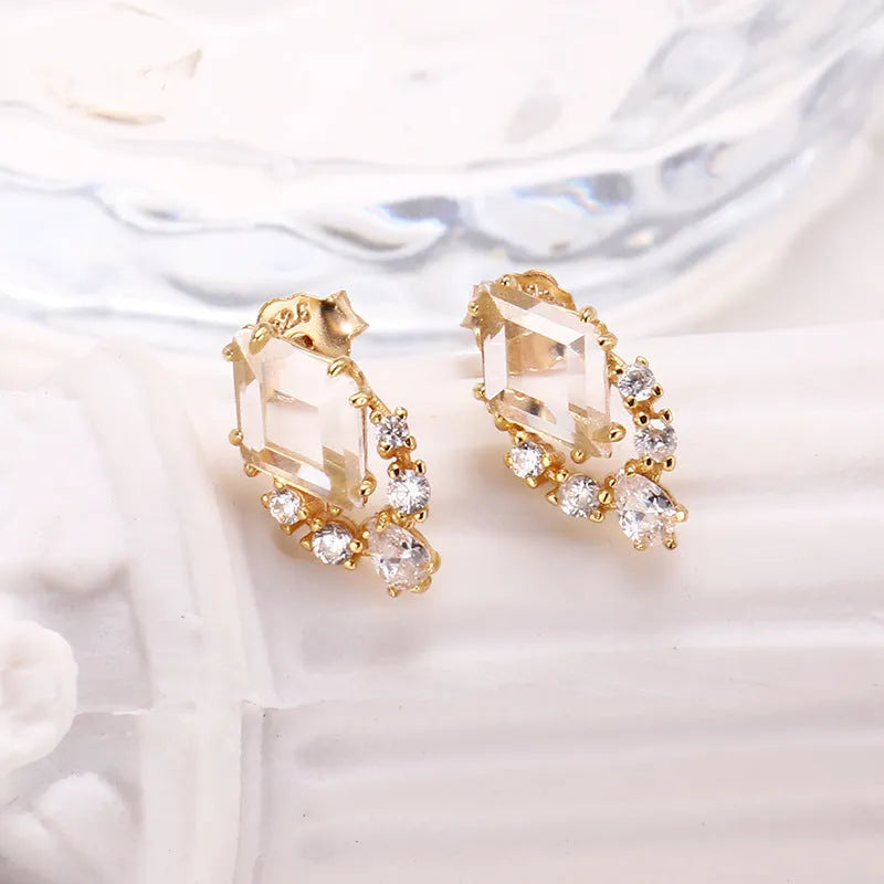 Geometric silver earrings with white crystal studs showing front detail