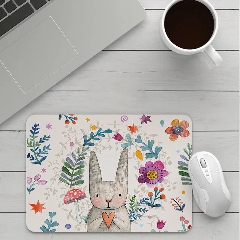 Thick custom cartoon mouse pad with colourful design on a desk, showing black seam edge