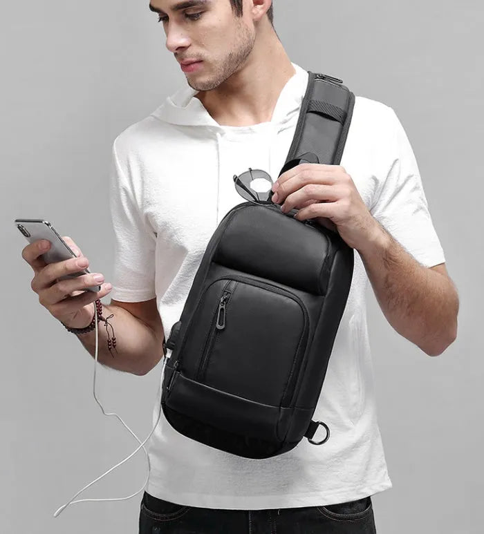 Black medium outdoor PVC shoulder bag with an air cushion strap and organiser pockets.