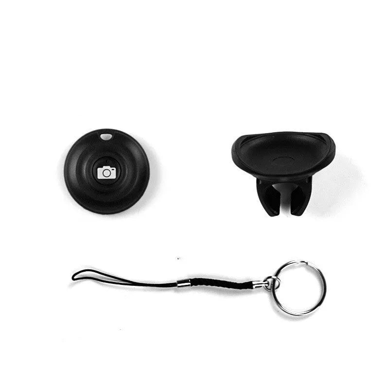 Small black Snap Bluetooth remote shutter on a hand, showing single button.