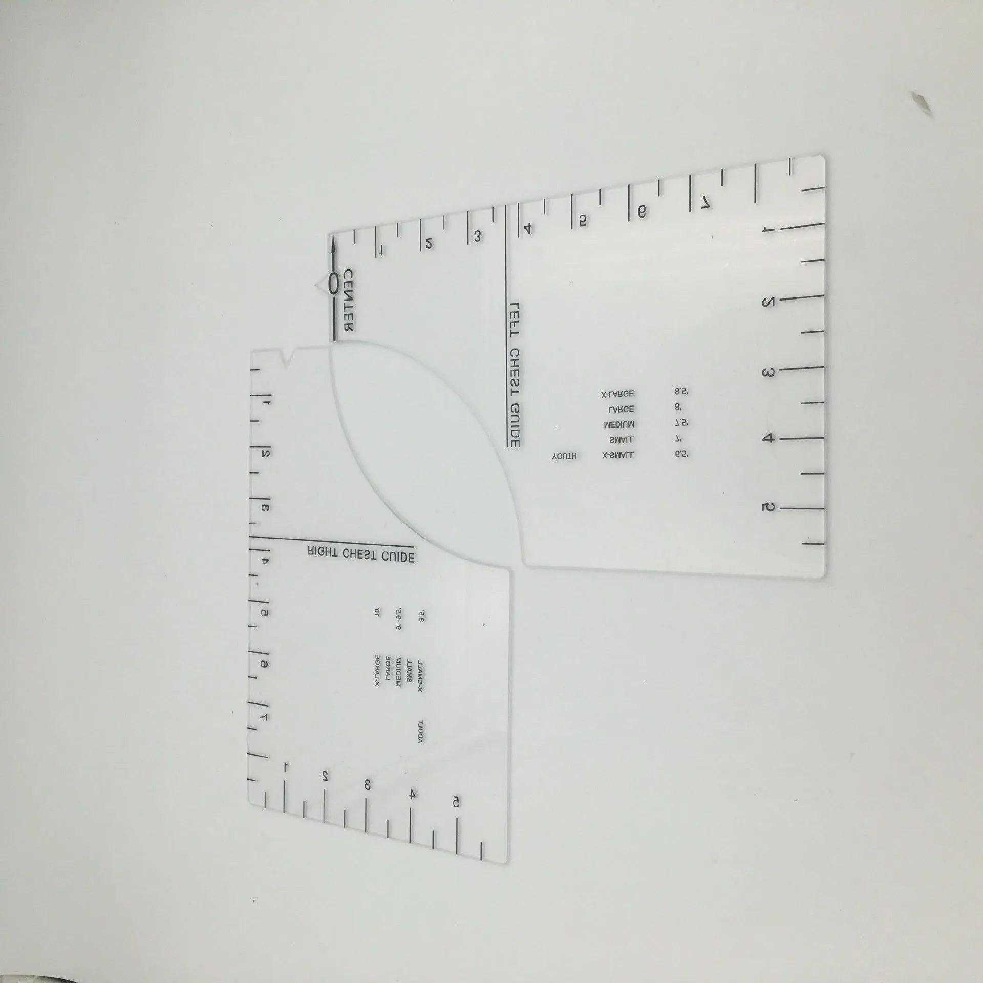 Transparent acrylic sewing ruler for T-shirt alignment and patch placement on fabric.