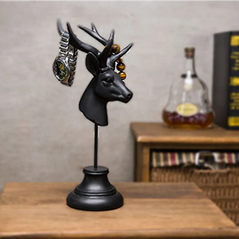 A tall black animal-shaped decorative ornament made from natural resin on a wooden shelf.
