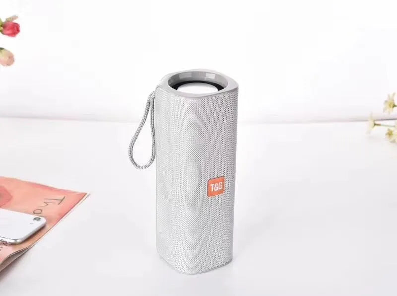 Cloth wireless Bluetooth speaker in multiple colours showing front grill and control buttons.