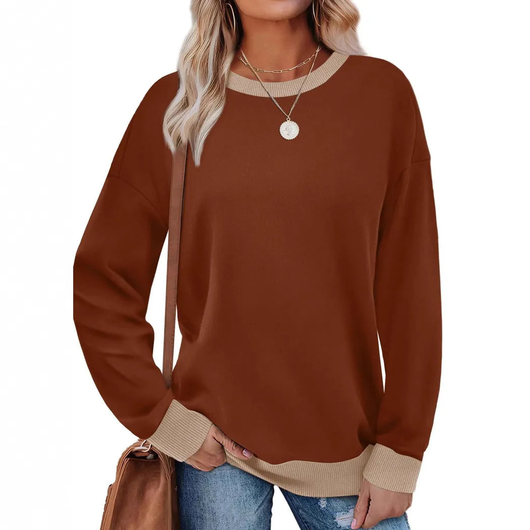Woman wearing a loose-fitting striped long sleeve top with a round neckline in a grey colour.