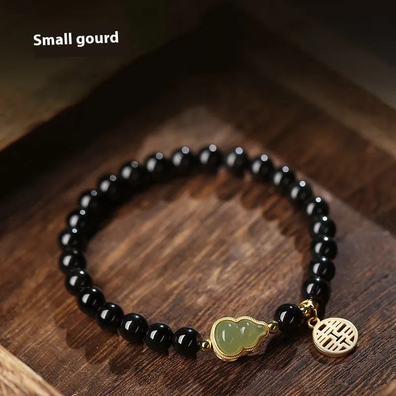 Black obsidian bracelet with a Hetian jade gourd charm, shown in couple style with geometric beads.