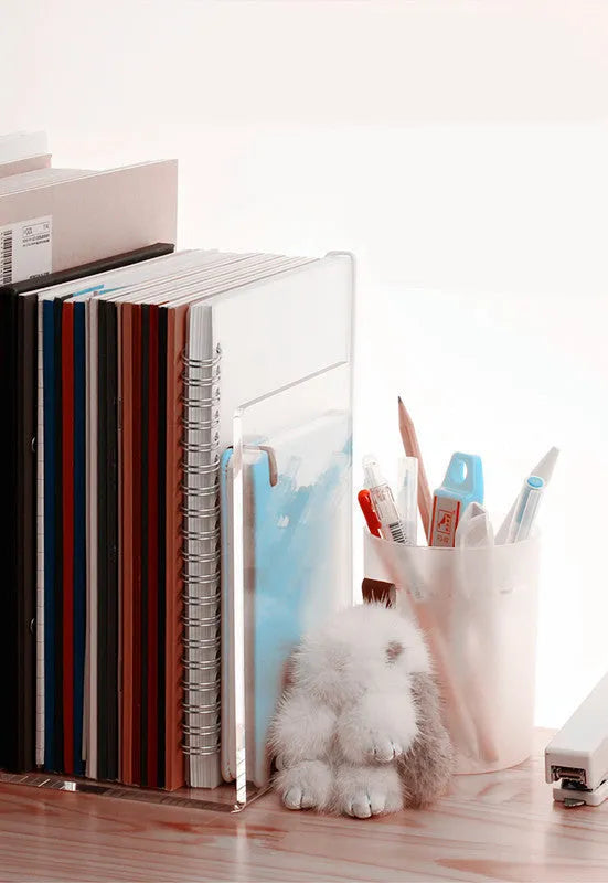Clear transparent acrylic bookshelf holding a pair of books on a desk.