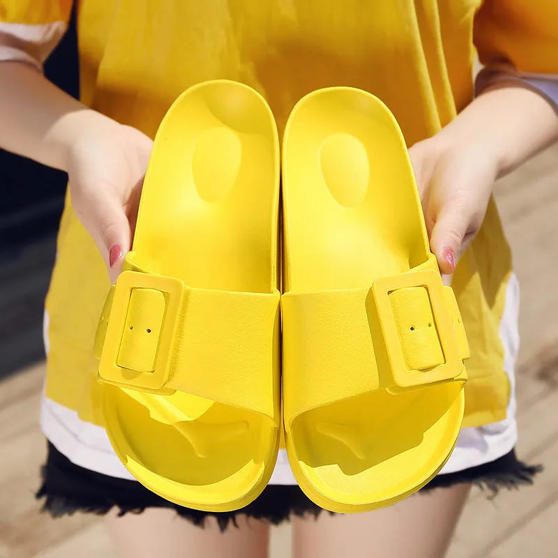 Women's grey blue EVA flip-flop sandals with a silver buckle on the strap, showing flat sole.