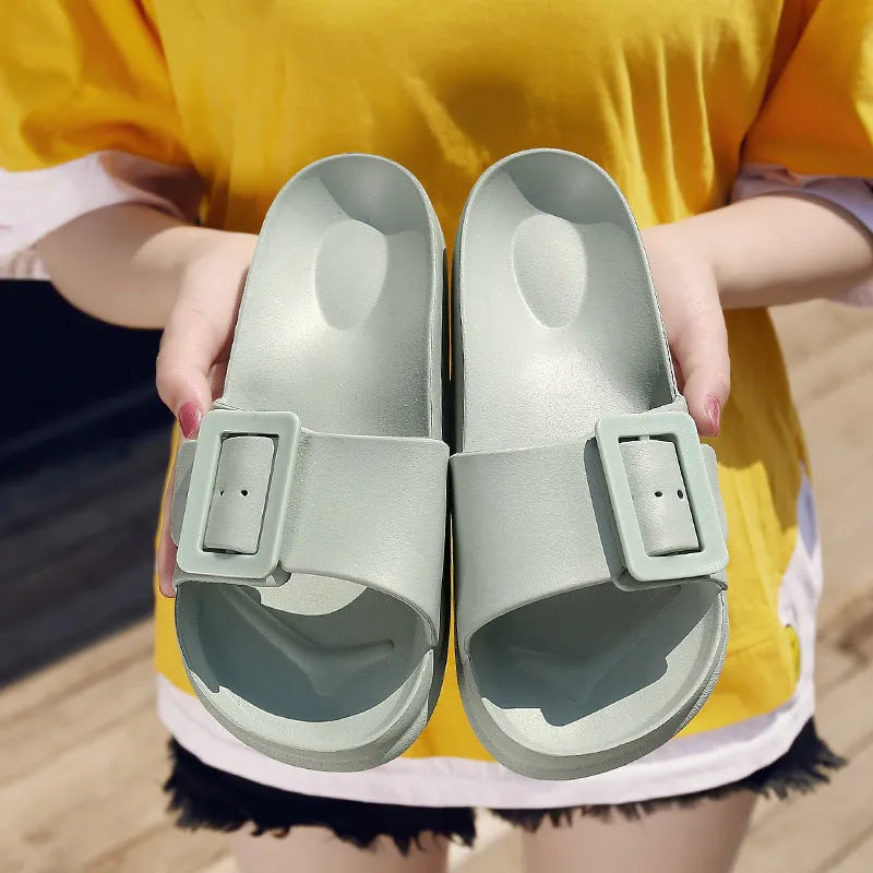 Women's grey blue EVA flip-flop sandals with a silver buckle on the strap, showing flat sole.