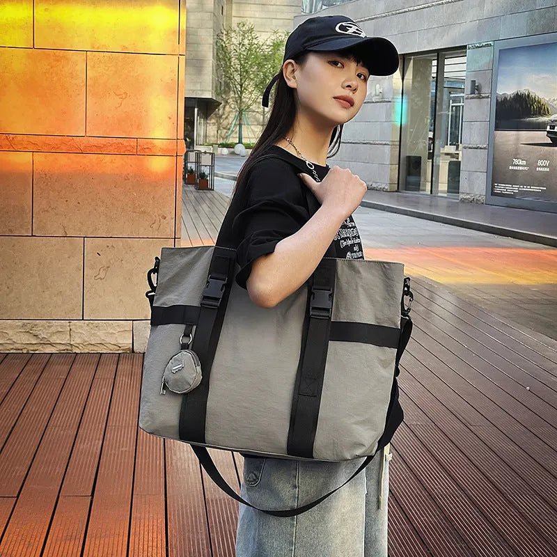 Men's grey Oxford cloth travel shoulder bag showing large main compartment and separate coin purse.