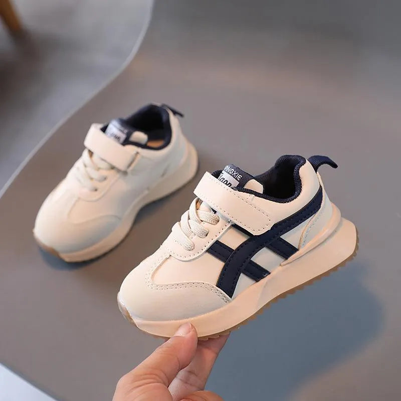 Children's white casual sneaker with Velcro strap, synthetic leather upper, and rubber sole on a neutral background.