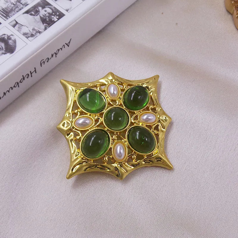 Close-up of vintage medieval baroque cross brooch with crystal accents on zinc alloy.