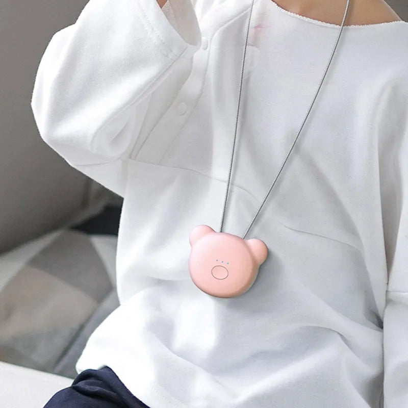 Mini USB portable air purifier necklace in pink, showing compact size and wearable design.