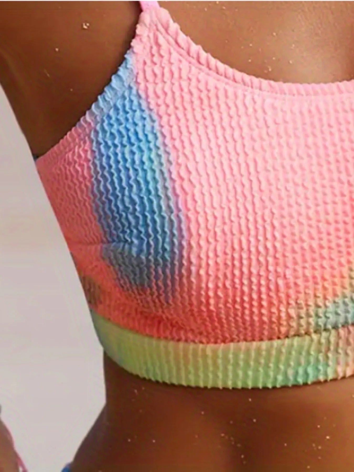 Women's blue and orange tie-dye pleated split bikini on a white background.