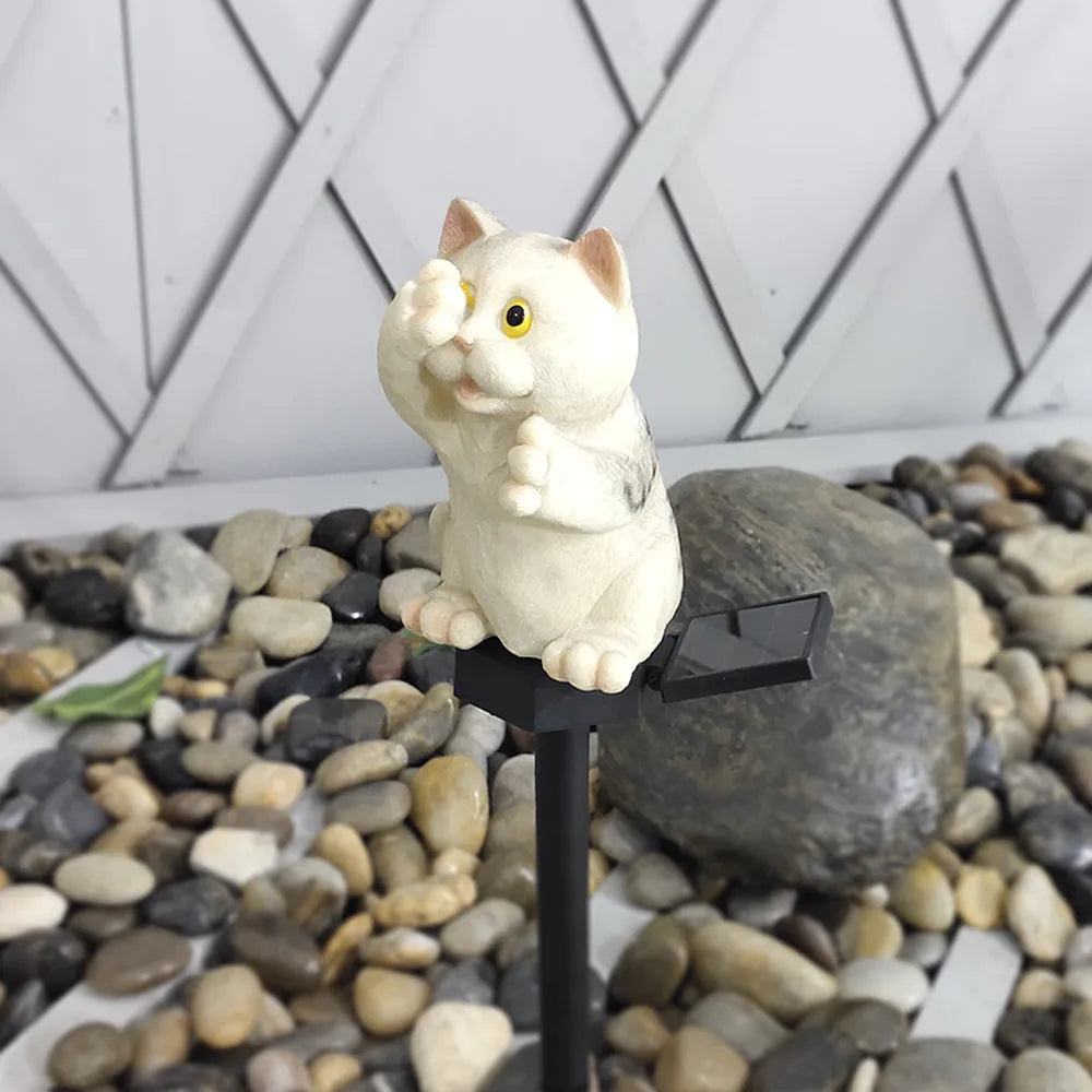Brown cat-shaped solar lawn light with LED, placed in a garden.