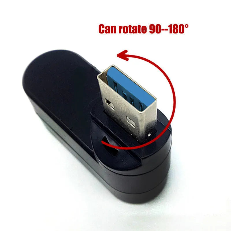 Black and white USB 3.0 four-port rotary splitter hub on a desk next to a laptop