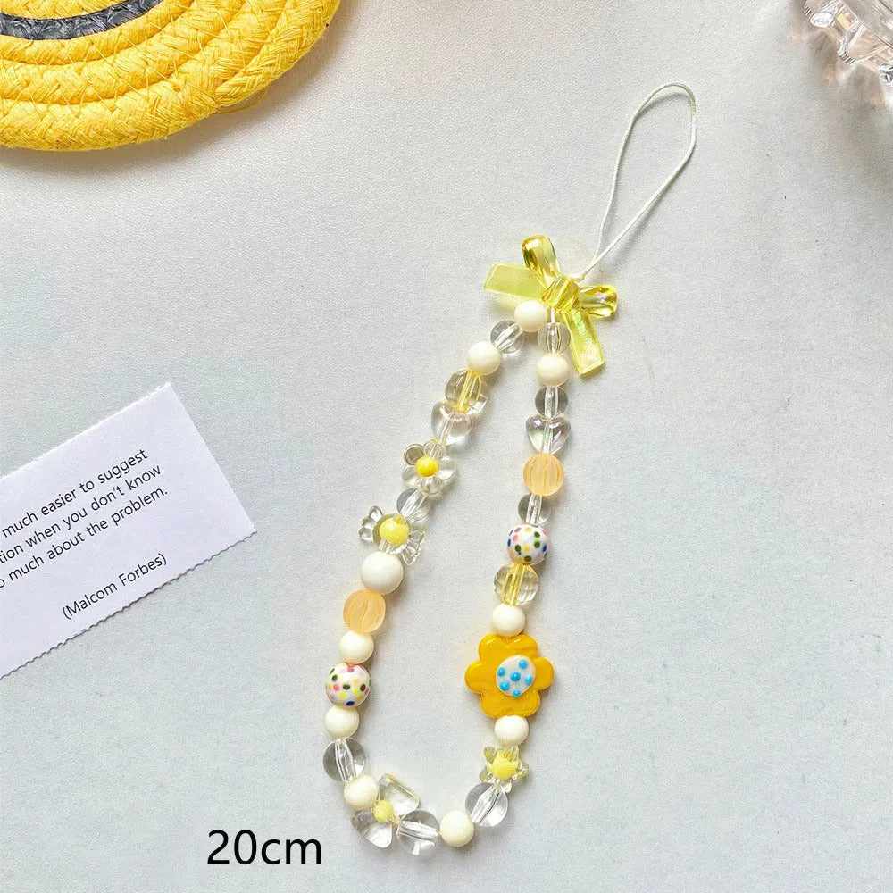 Yellow beaded flower mobile phone lanyard with plastic resin beads on a white background.