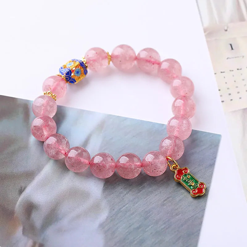 Pink strawberry quartz bracelet with Chinese Ruyi charms and engraved text on wrist