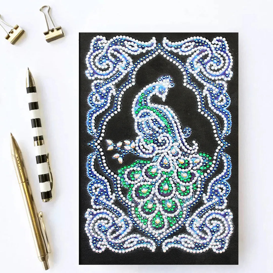 Black A5 diamond painting notebook open, showing journal pages alongside shaped and bright sparkling drills.