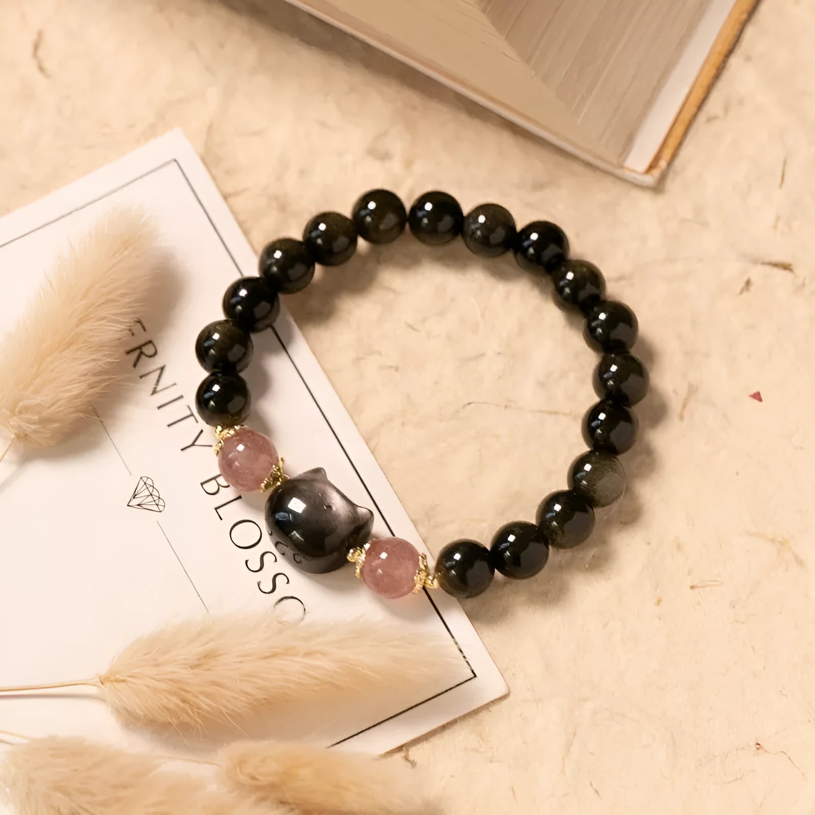 Black natural obsidian bead bracelet with a kitty charm on a stretch cord.
