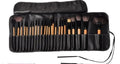 24 professional makeup brushes with wooden handles stored in a black PU gift bag.