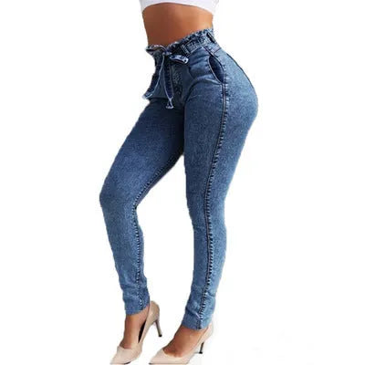 Pair of blue fringed jeans with a distressed hem laid flat, showing cowboy fabric texture.