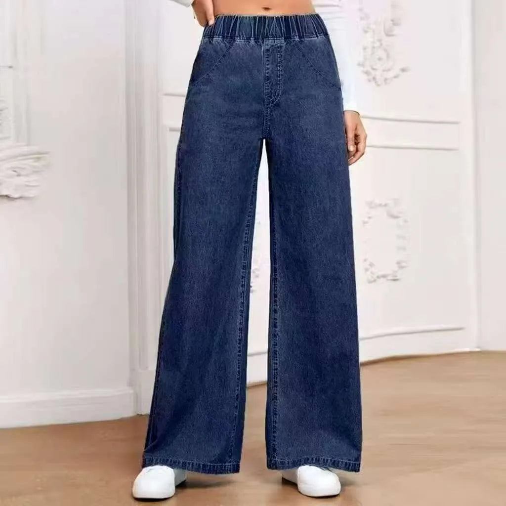 Light blue washed wide-leg denim trousers on a hanger, showing straight cut and mid-rise waist.