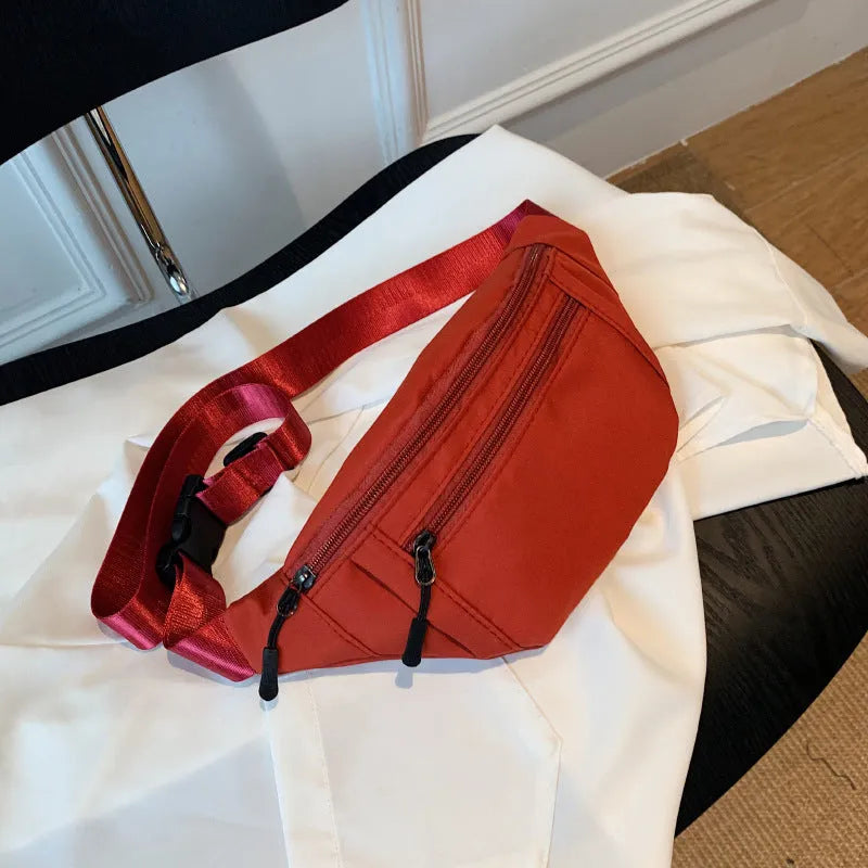 Soft nylon multi-layer mobile phone waist bag with crossbody strap, three-dimensional pocket, and sewing thread detail.