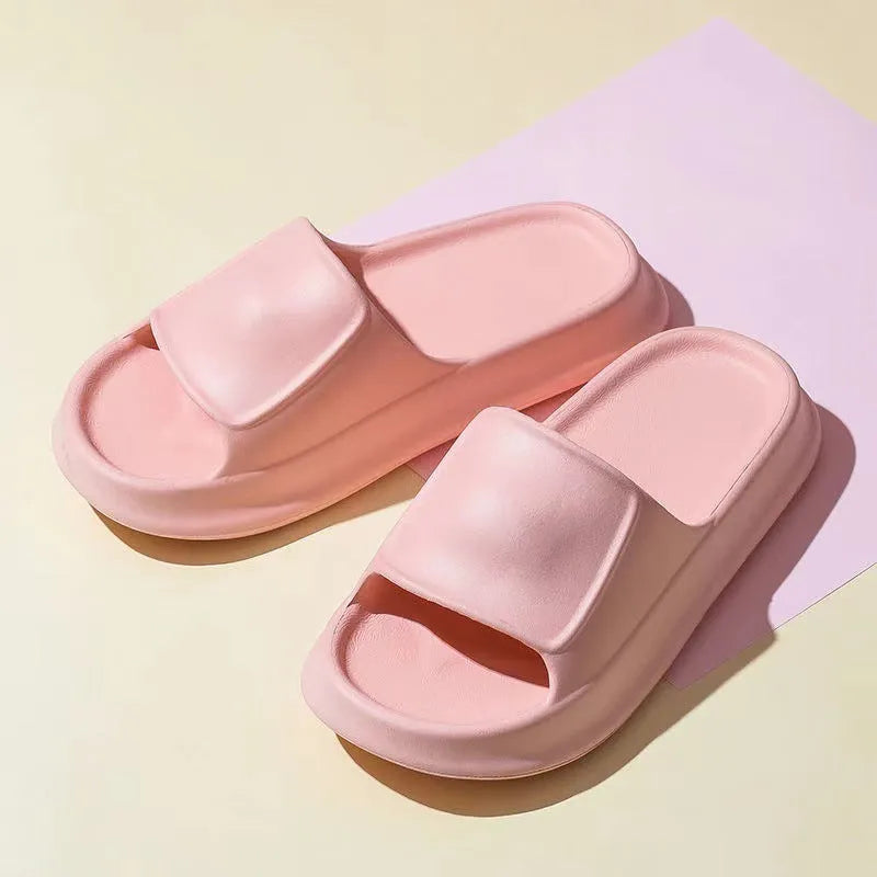 Pair of white EVA flip-flop slippers with a thick, textured sole on a tiled floor.