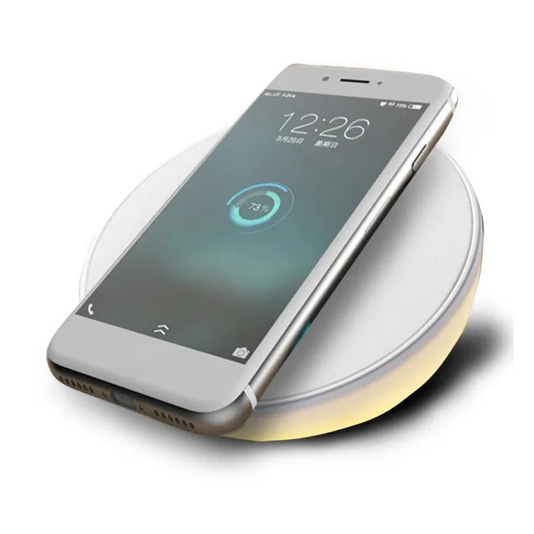White wireless charging pad with LED clock display showing time, three control buttons, and Qi charging surface for smartphones