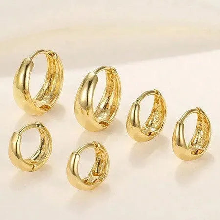 Three pairs of gold electroplated copper earrings with geometric ring design on a white background