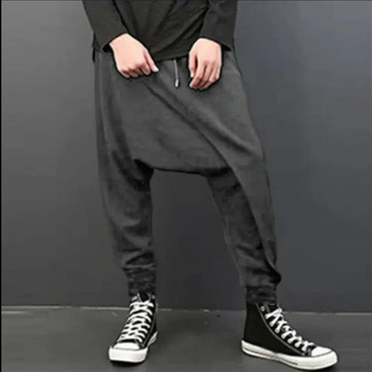 Cotton loose harem pants in black with elastic waist, side view on model