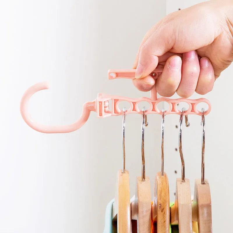 Blue revolving wardrobe hanger with five plastic branches and central handle for clothes organisation