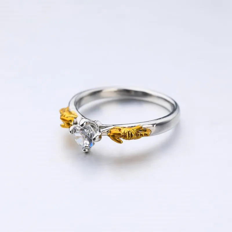 Copper crown model ring with black gold finish on a plain background, showing detailed peaks and band.